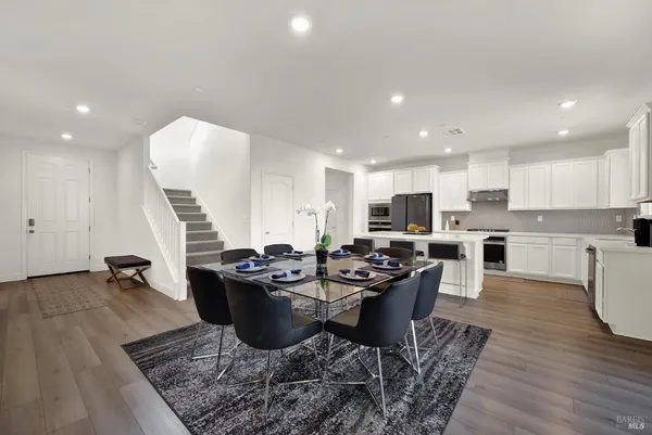 a living room with furniture kitchen view and a flat screen tv