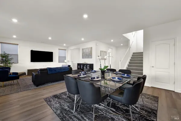 a living room with furniture kitchen view and a large window