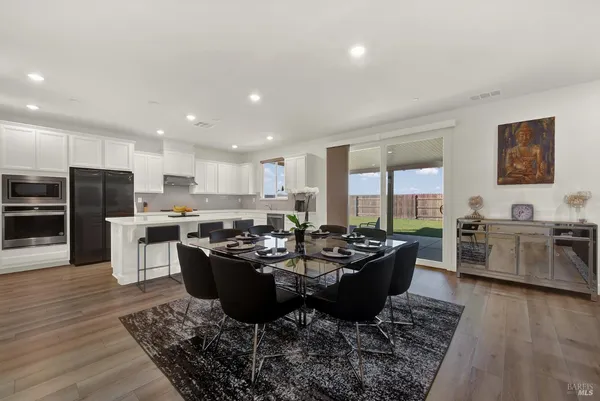 a kitchen with a refrigerator a stove a sink and chairs