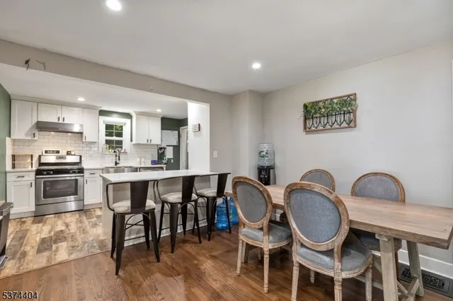 a kitchen with granite countertop kitchen island stainless steel appliances a dining table and chairs