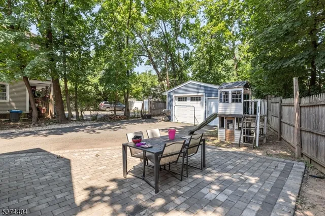 a patio with a table and chairs and potted plants