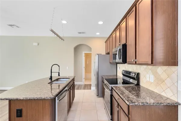 a kitchen with stainless steel appliances granite countertop a sink stove and refrigerator