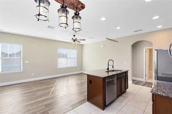 a kitchen with stainless steel appliances granite countertop a sink a counter space and a window