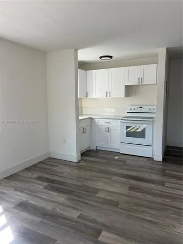 a view of kitchen with granite countertop cabinets and stove top oven