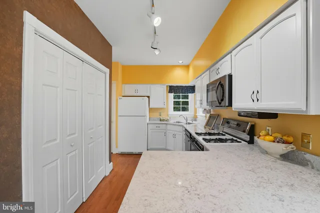 a kitchen that has a lot of cabinets in it and wooden floor