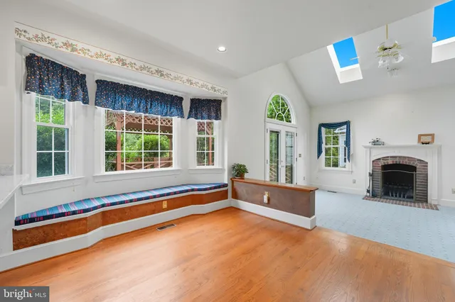 an empty room with chandelier fan and windows
