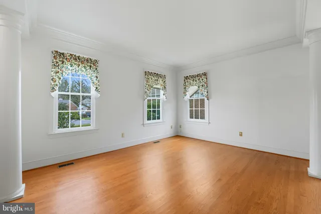 an empty room with wooden floor and entrance