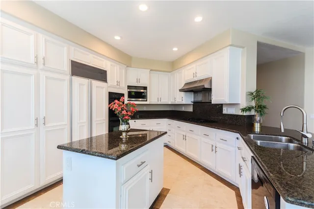 a kitchen with stainless steel appliances granite countertop a sink a stove counter space and cabinets