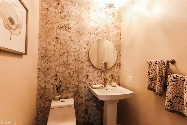 a bathroom with a granite countertop sink mirror vanity and toilet