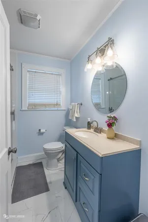 a bathroom with a toilet sink vanity granite and mirror