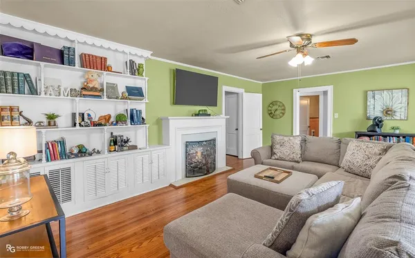 a living room with furniture a fireplace and a flat screen tv
