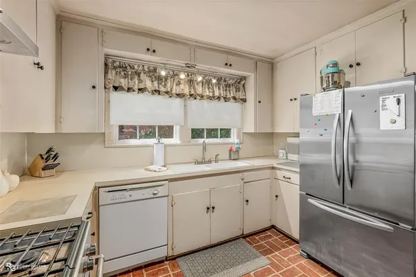 a kitchen with a refrigerator sink and cabinets