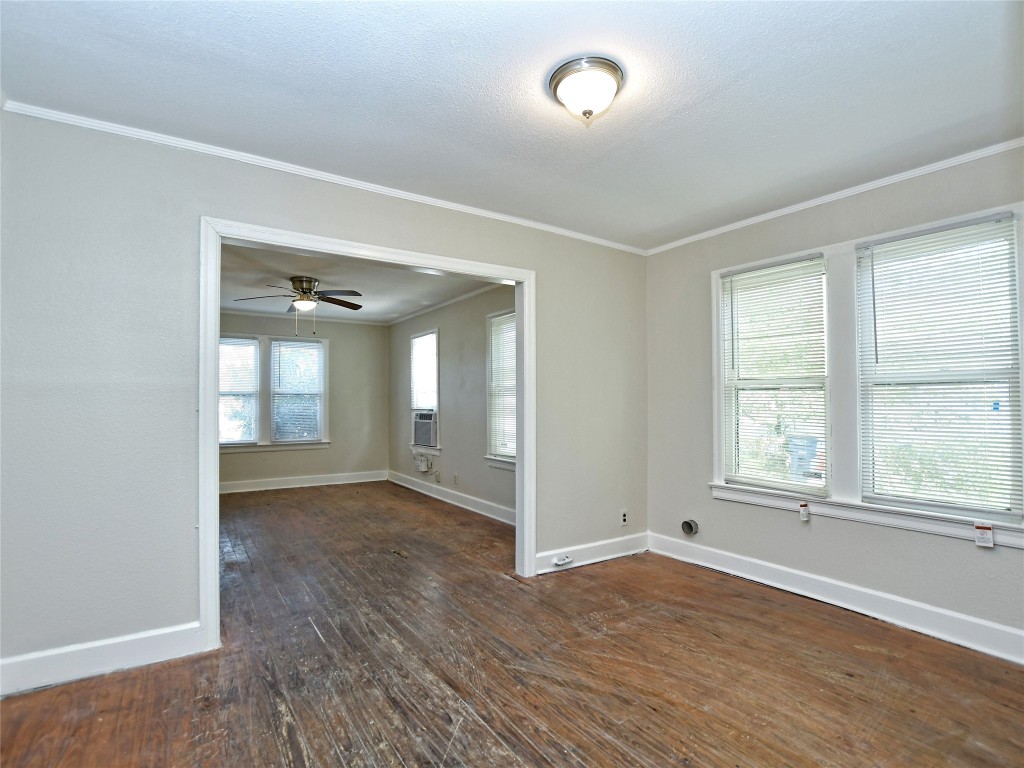 4305 Red River Street Austin, TX 78751 - Photo 5 of 9 Unfurnished room featuring dark wood-type flooring, ornamental molding, baseboards, and ceiling fan