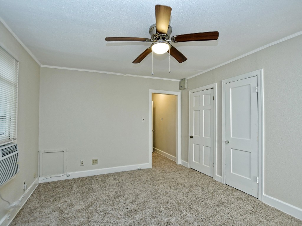 4305 Red River Street Austin, TX 78751 - Photo 8 of 9 Unfurnished bedroom featuring ornamental molding, carpet flooring, baseboards, and ceiling fan