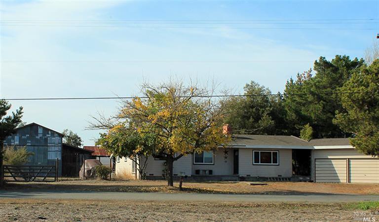 21977 Bonness Road Sonoma, CA 95476 - Photo 1 of 1 a view of a white house next to a yard with plants and trees