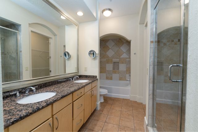 a bathroom with a granite countertop sink mirror and shower