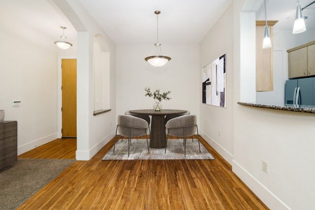 a dining room with wooden floor a chandelier a wooden table and chairs