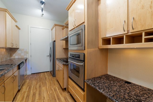 a kitchen with stainless steel appliances granite countertop a stove and a refrigerator