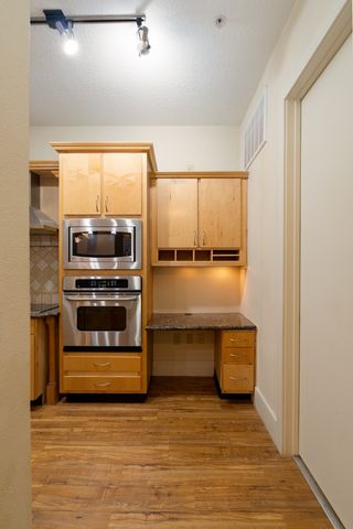 a view of kitchen with stainless steel appliances granite countertop a stove and a microwave oven