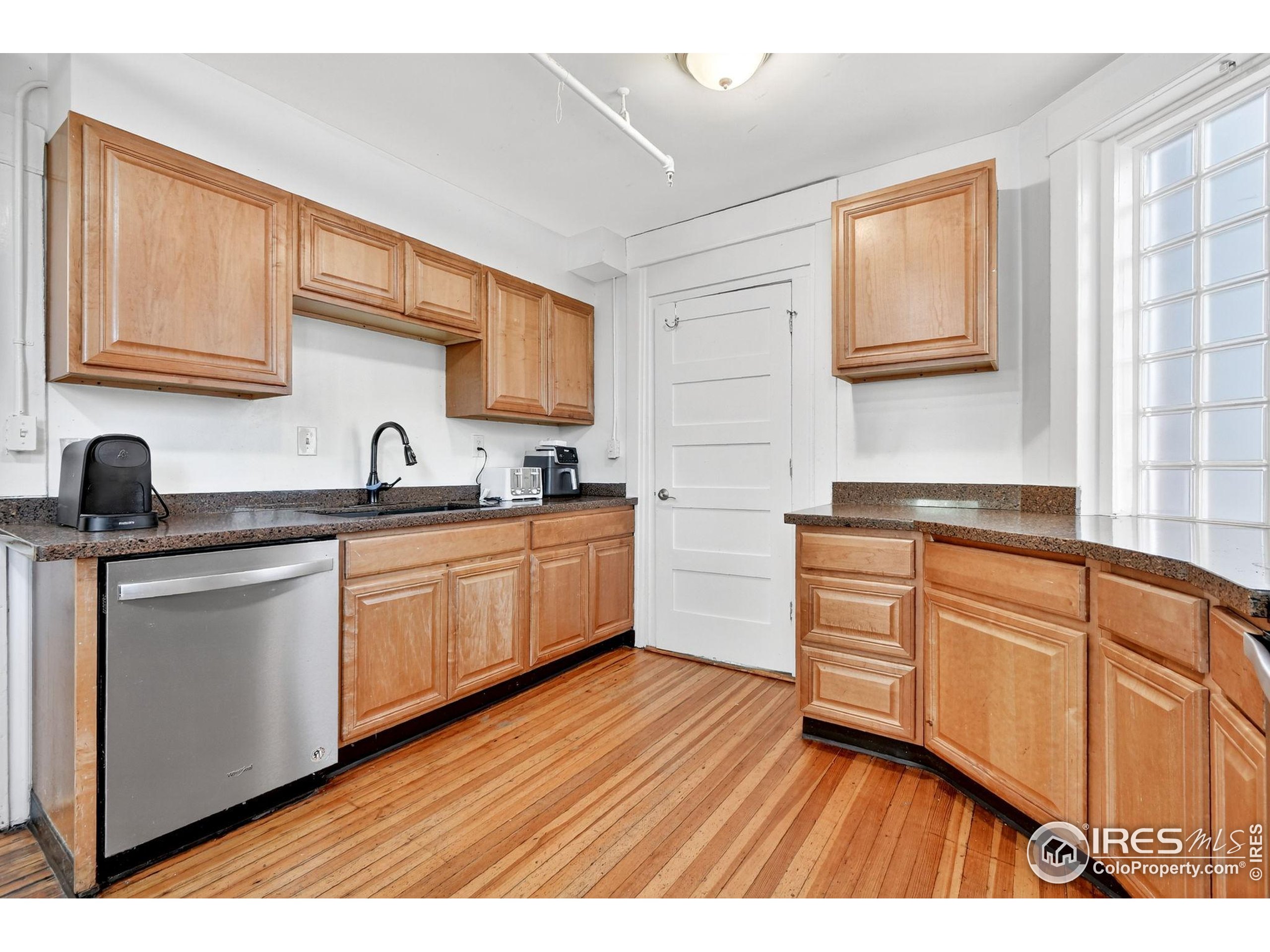 972 Pleasant Street Boulder, CO 80302 - Photo 12 of 36 a kitchen with stainless steel appliances granite countertop a sink cabinets and wooden floor
