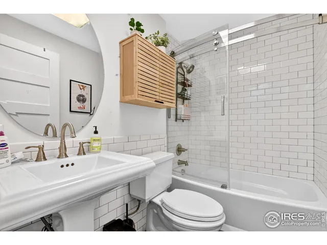 a bathroom with a sink toilet a mirror and shower