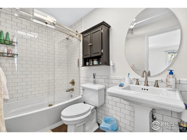 a bathroom with a sink toilet mirror and shower