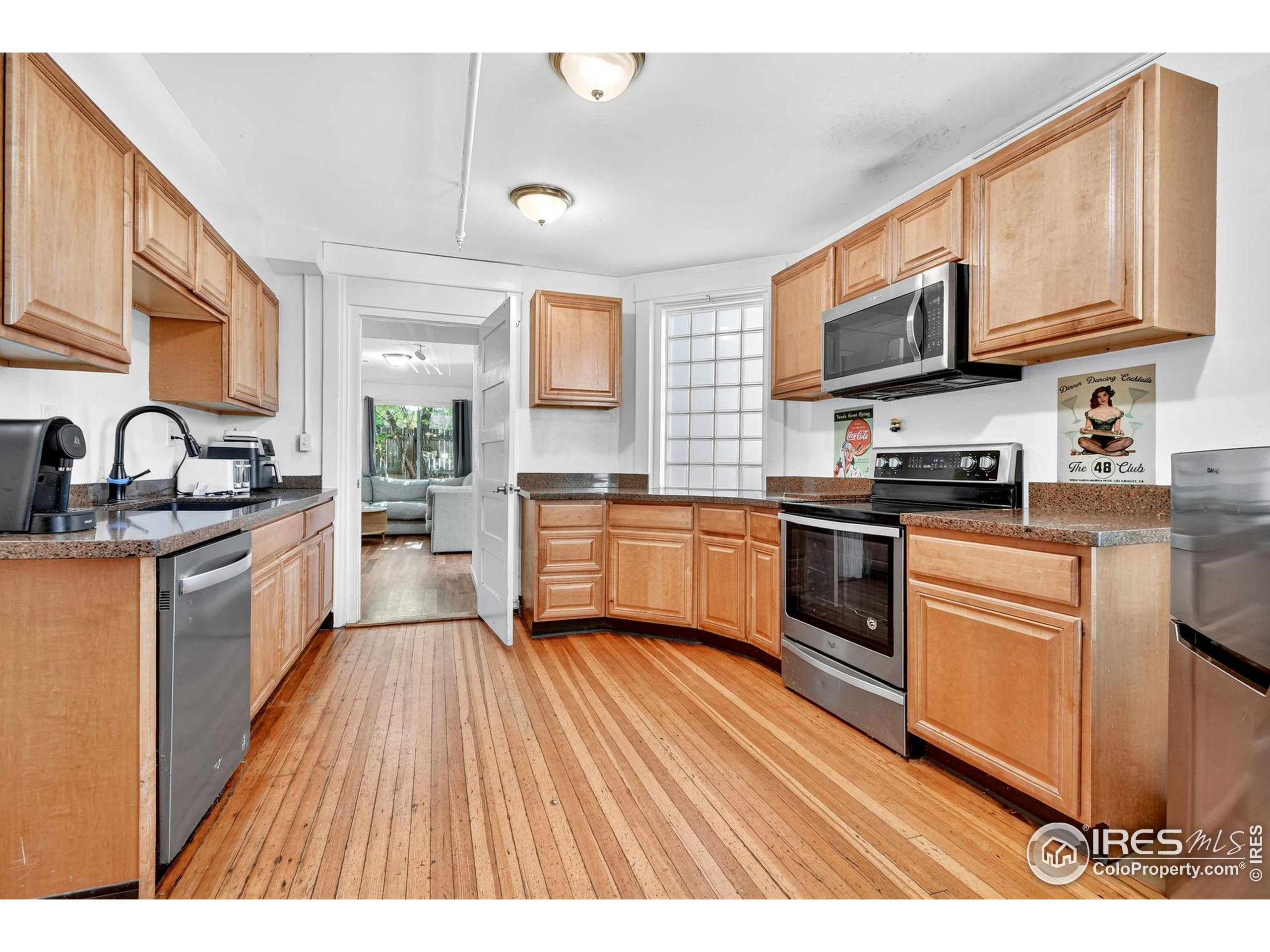 972 Pleasant Street Boulder, CO 80302 - Photo 4 of 36 a kitchen with stainless steel appliances granite countertop wooden cabinets a sink dishwasher a stove and a refrigerator with wooden floor