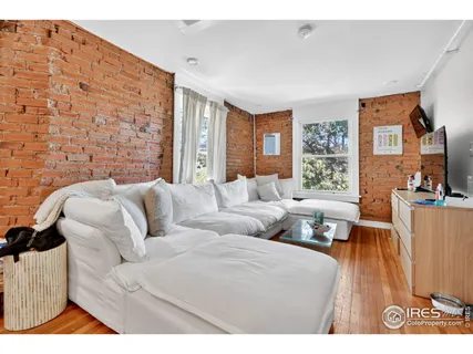 a living room with furniture a flat screen tv and a window