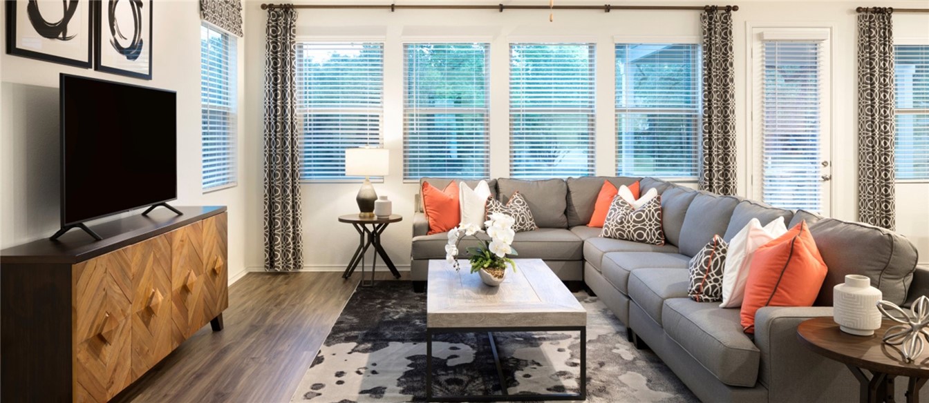 a living room with furniture a flat screen tv and a large window