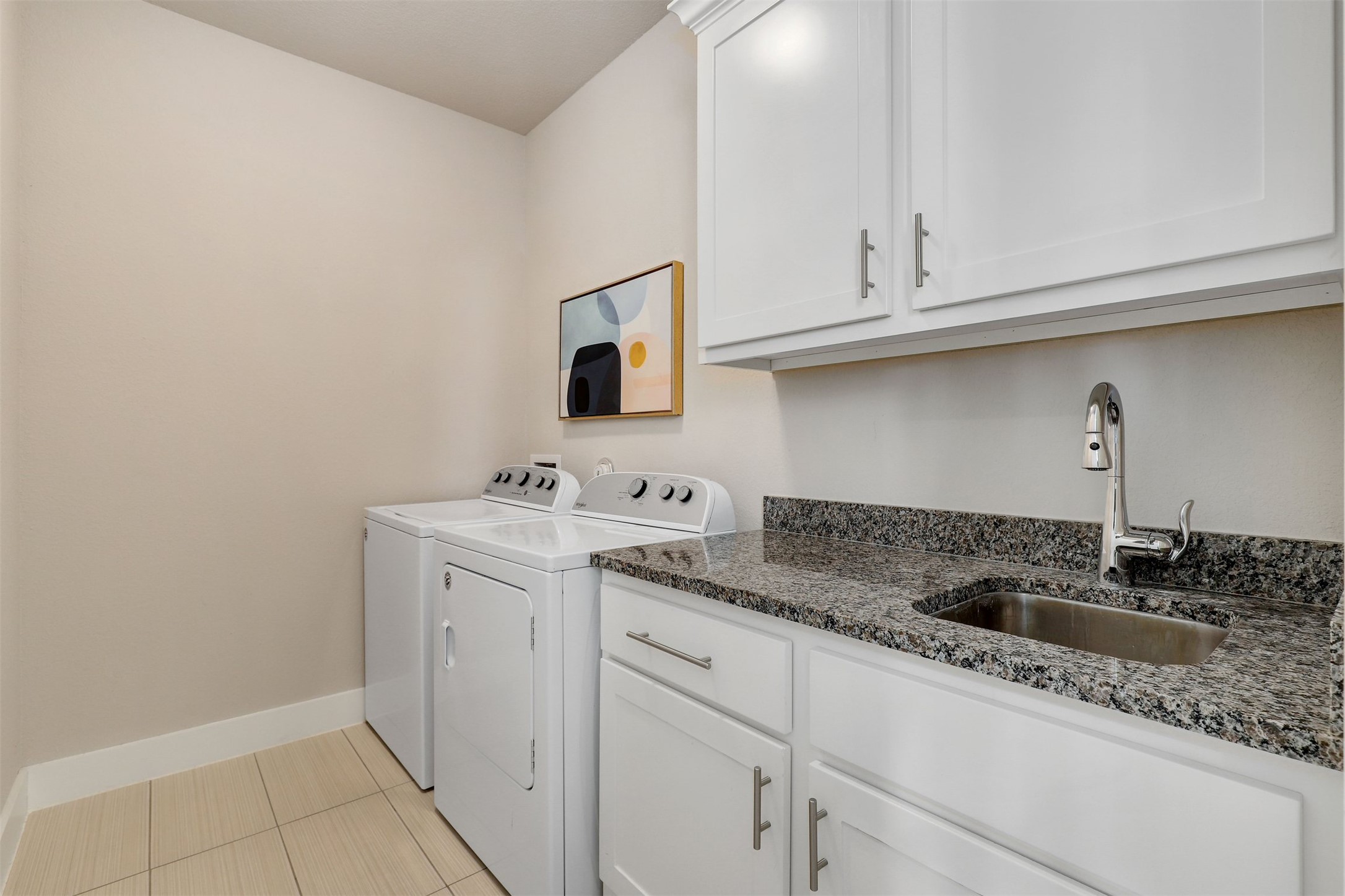 5502 Patagonia Pass Austin, TX 78738 - Photo 24 of 34 Laundry room with washing machine and dryer, cabinet space, and light tile patterned flooring