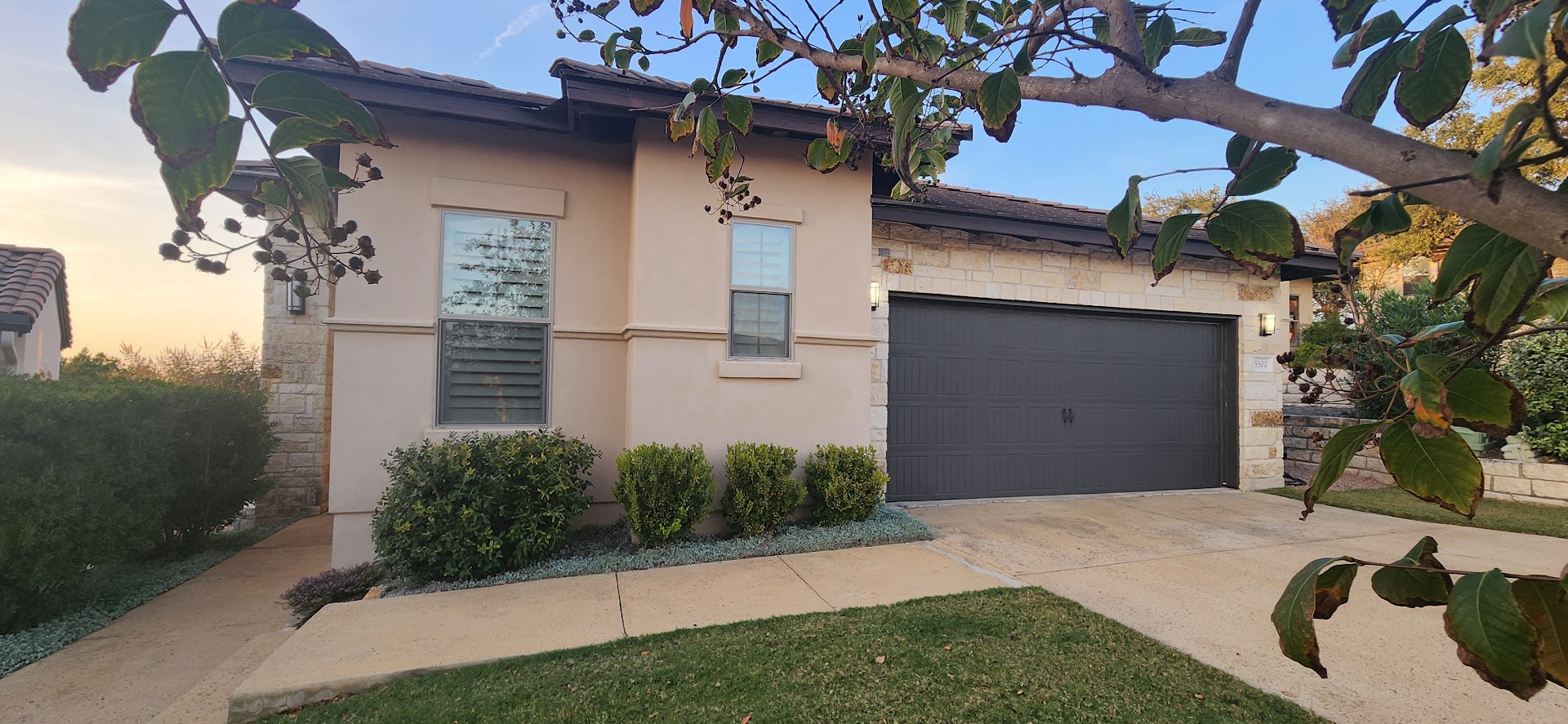 5502 Patagonia Pass Austin, TX 78738 - Photo 27 of 34 View of front of home featuring stone siding, stucco siding, driveway, and an attached garage