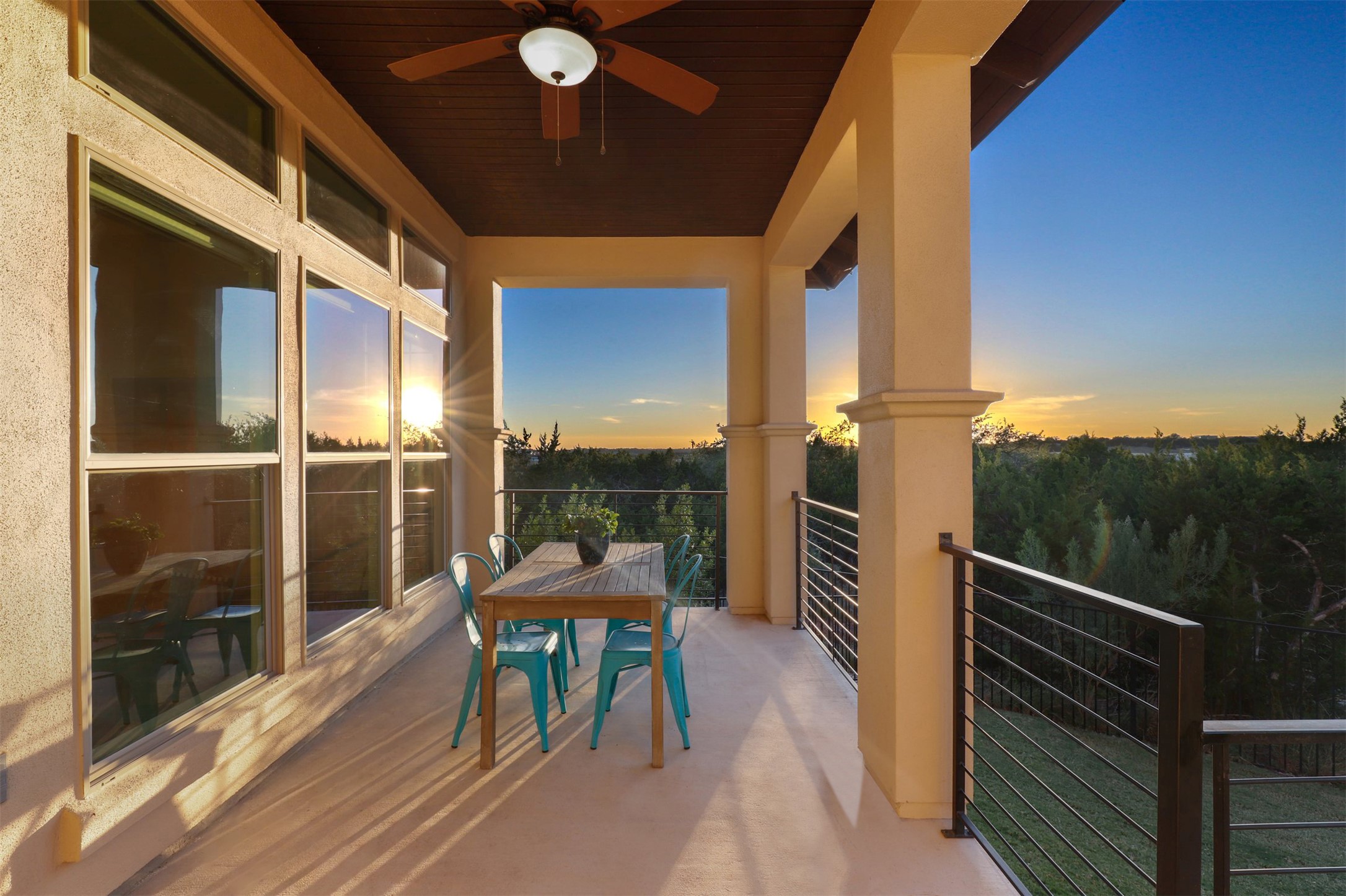 5502 Patagonia Pass Austin, TX 78738 - Photo 3 of 34 Balcony at dusk with a ceiling fan and outdoor dining space