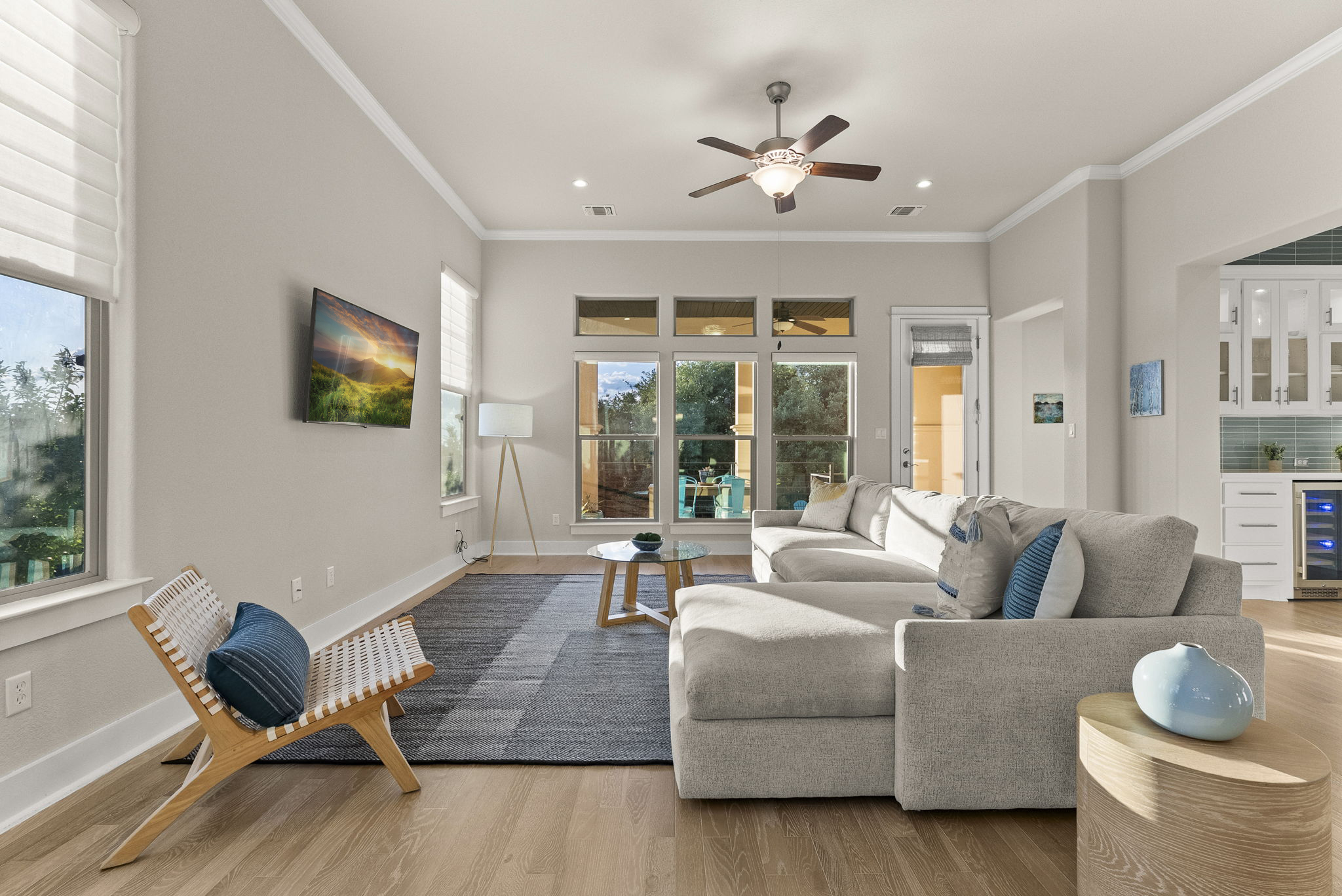 5502 Patagonia Pass Austin, TX 78738 - Photo 6 of 34 Living room featuring beverage cooler, crown molding, light wood-style flooring, a ceiling fan, and recessed lighting
