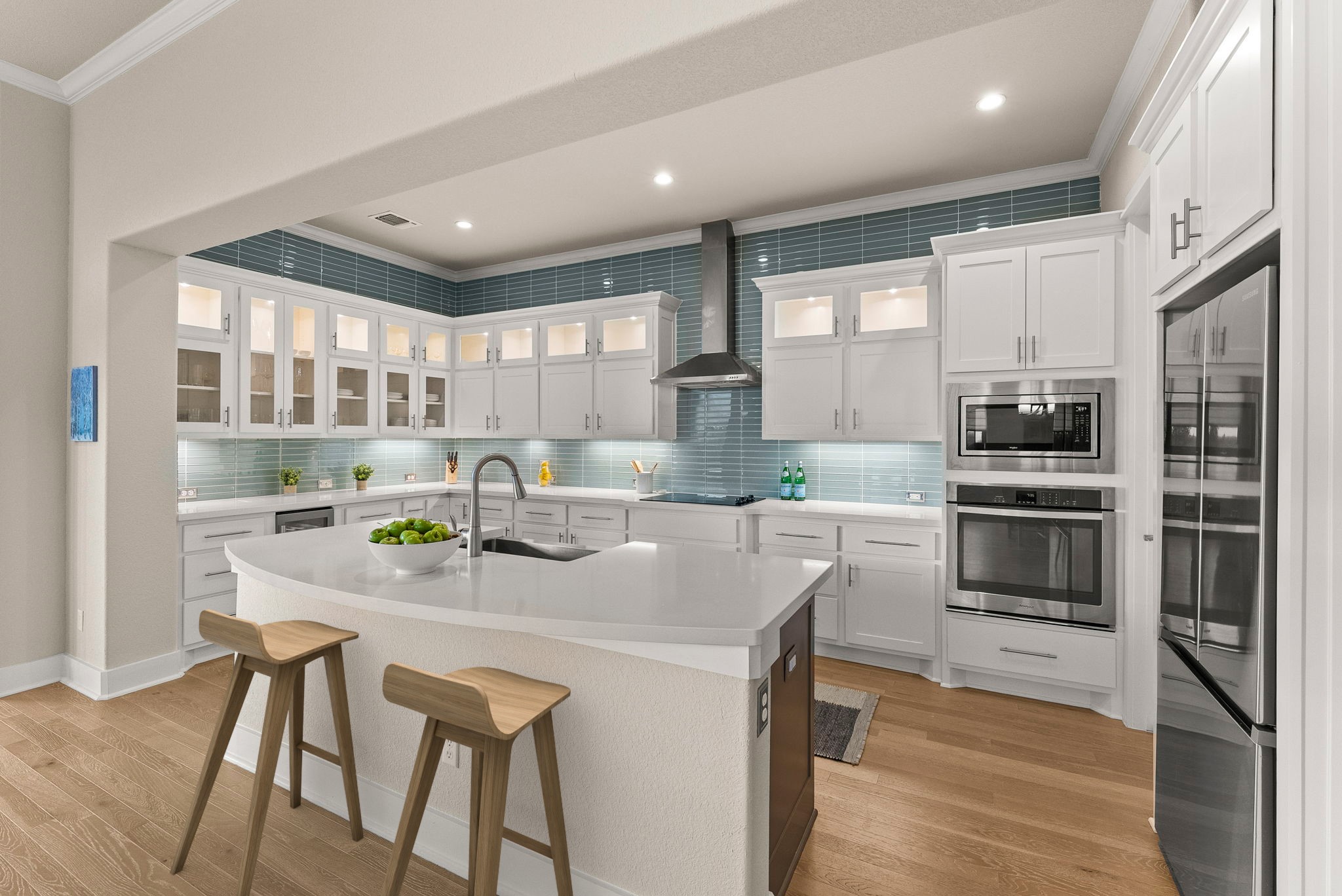 5502 Patagonia Pass Austin, TX 78738 - Photo 9 of 34 Kitchen featuring glass insert cabinets, ornamental molding, a breakfast bar area, white cabinetry, and built in appliances