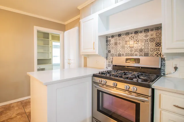 a kitchen with a stove a sink and a window