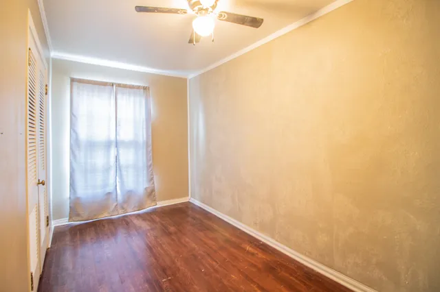 a view of an empty room with wooden floor