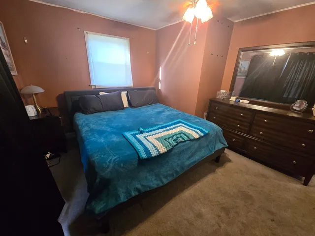 a bed sitting in a bedroom next to a window