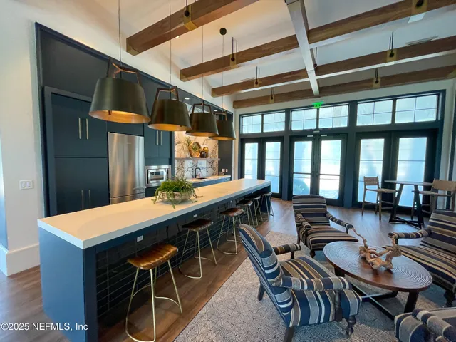 a room with stainless steel appliances kitchen island granite countertop a dining table and chairs with wooden floor