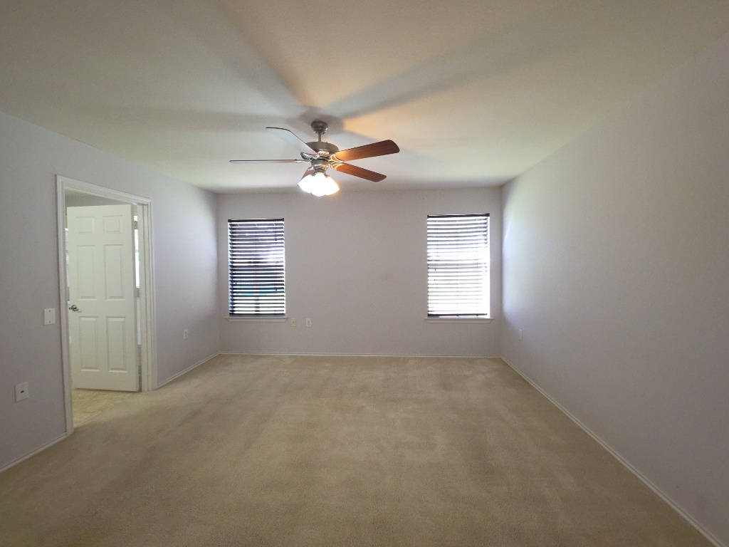 9005 Sun Shower Bend Austin, TX 78724 - Photo 11 of 20 an empty room with windows and fan