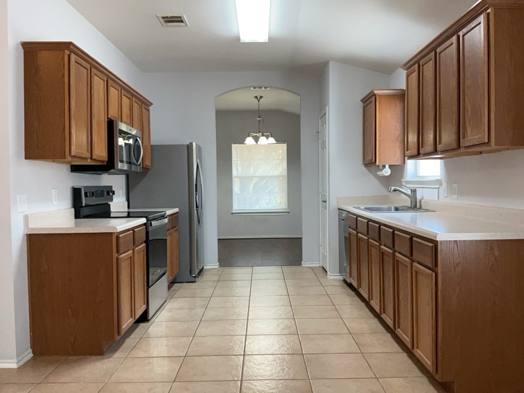 9005 Sun Shower Bend Austin, TX 78724 - Photo 5 of 20 a kitchen with stainless steel appliances granite countertop a stove a sink and a microwave