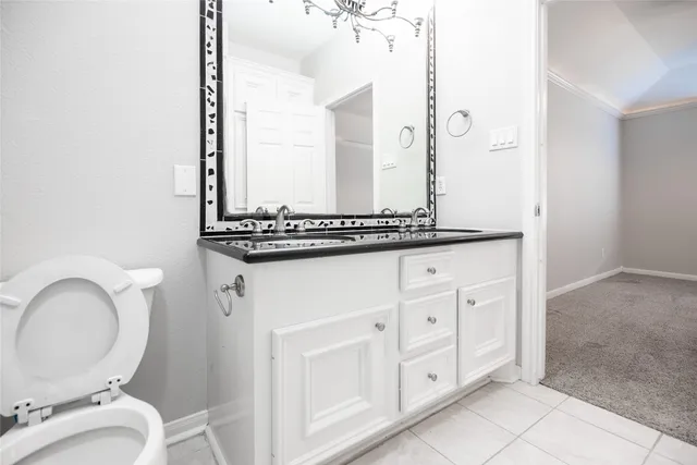 an empty room with a chandelier fan and windows