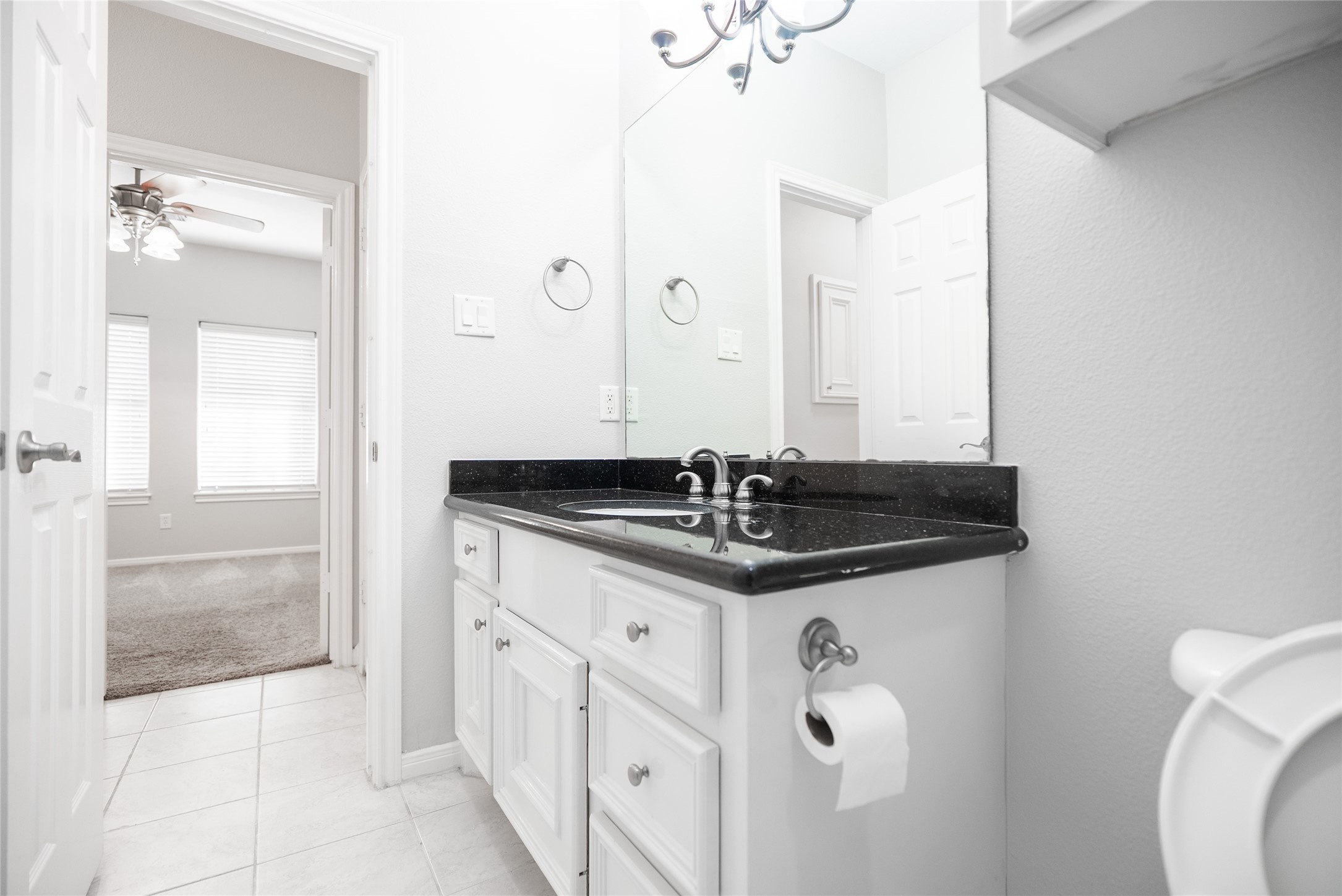 13165 Snow Lane, Unit 1 Willis, TX 77318 - Photo 24 of 34 a bathroom with a granite countertop sink a toilet a mirror and shower
