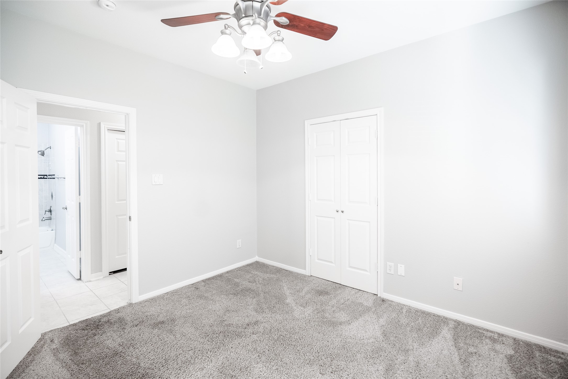 13165 Snow Lane, Unit 1 Willis, TX 77318 - Photo 26 of 34 an empty room with a chandelier fan and windows