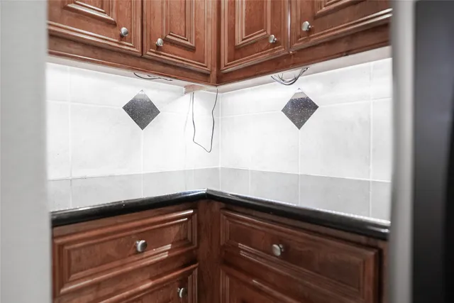 an empty room with windows and chandelier fan