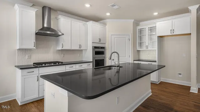 a kitchen with stainless steel appliances granite countertop a sink a stove and a refrigerator