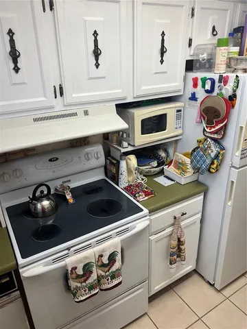 a stove top oven sitting inside of a kitchen with stainless steel appliances wooden floor and a stove