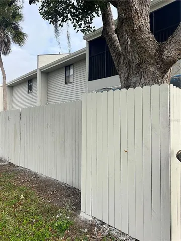 a side view of a house with a wooden fence