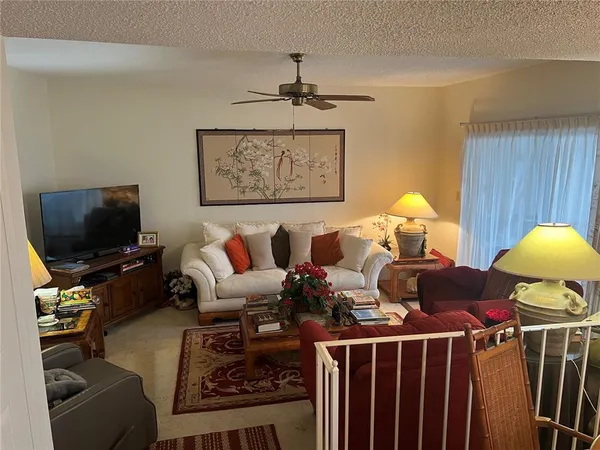 a living room with furniture a flat screen tv and a window