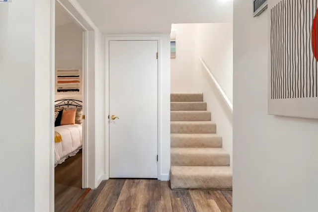 a view of a hallway with wooden floor and a livingroom