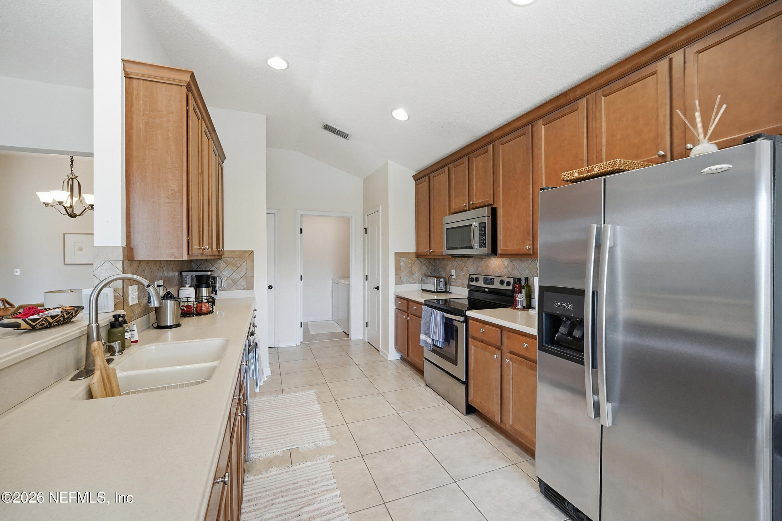 374 Porta Rosa Circle St. Augustine, FL 32092 - Photo 13 of 47 a kitchen with stainless steel appliances granite countertop a refrigerator sink and stove